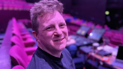 Ben Occhipinti, Sound Designer, sat with the sound and light controls behind him