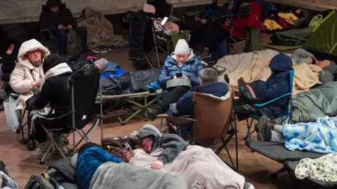 AFP via Getty Images People take shelter at a metro station during a Russian air attack, in Kyiv, on early February 3, 2026.
