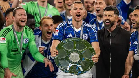 Edin Dzeko of FC Schalke 04 lifts the Meisterschale trophy as Schalke celebrates its league title victory after the 2. Bundesliga match