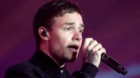 Reuters Liam Payne sings into a microphone