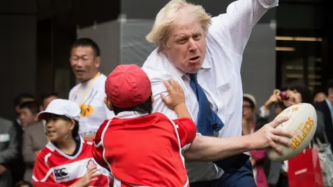 PA Media Boris Johnson joining a Street Rugby tournament in a Tokyo street with school children and adults