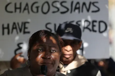 ADRIAN DENNIS / AFP Members of the Chagossian community gather with banners and placards outside the parliament in London, the UK.