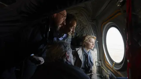 EPA Greek Prime Minister Kyriakos Mitsotakis (2-L) with European Council President Charles Michel (L), European Commission President Ursula von der Leyen (R) and European Parliament President David Sassoli (bottom, back to camera), looking out of the window of a helicopter during a flight over Evros, at the Greek-Turkish border in northern Greece, 03 March 2020