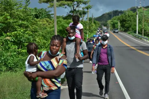 AFP Migrants from Ghana, Ivory Coast and DR Congo walk along the Pan-American in Honduras in June 2020. They are on their way to Mexico and ultimately the US. 