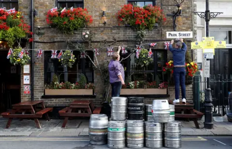 Reuters People decorate a pub with Union Flag bunting a day ahead of the royal wedding between Princess Eugenie and Jack Brooksbank in Windsor, Britain, October 11, 2018