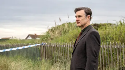 David Morrissey como Ian St Clair olhando para a distância