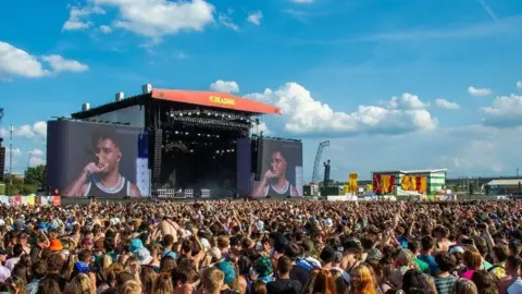 A general view of a crowd at the Reading Festival in 2022, with blue skies and clouds.