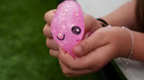 Getty Images A pink squishy toy in the hands of a young girl. 