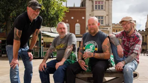 Chris Porsz Four men posing for a photo in Peterborough city centre