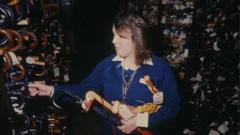 TfL A lost property office attendant sorts through hundreds of umbrellas in 1983, from London Transport Museum's collection