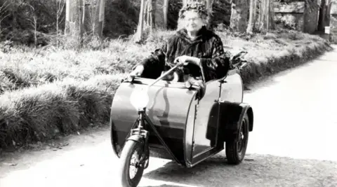 A black and white photo of Dame Sibyl Hathaway riding a carriage