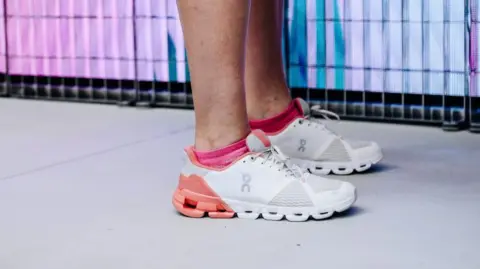 Bloomberg via Getty Images A pair of white and pink sneakers with holes in the sole