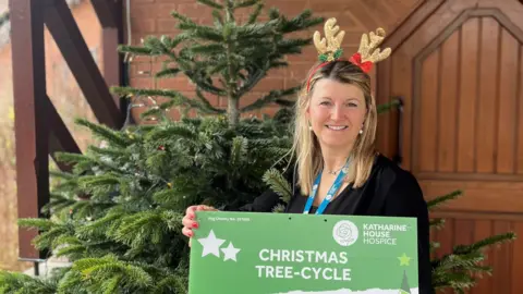 Carley Lambourne, Katharine House Events & Challenges Officer, promoting the hospice's Christmas Tree-cycle scheme.