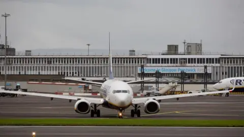 Getty Images An airplane on the runway in front of the main building at Glasgow Prestwick Airport