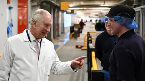 Getty Images King Charles speaks to staff on the cornflakes production line