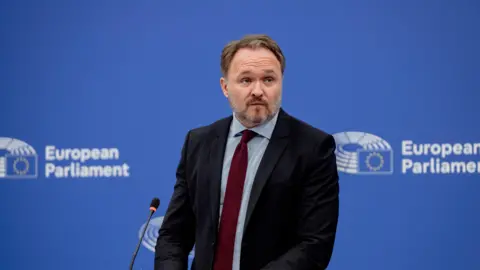 European Union Dan Jorgensen in suit and tie against a blue background