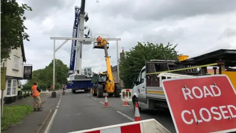 BBC Workers use a crane to remove the damaged Magpie pub's sign at Little Stonham, Suffolk