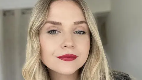 Kathryn Lee looks directly at the camera she has blonde hair and green eyes