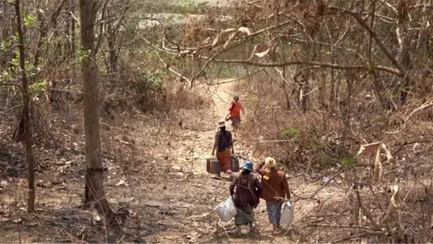 Myanmar nationals crossing the border through dirt tracks.