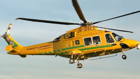 Dorset and Somerset Air Ambulance A yellow and green Dorset and Somerset Air Ambulance flying 