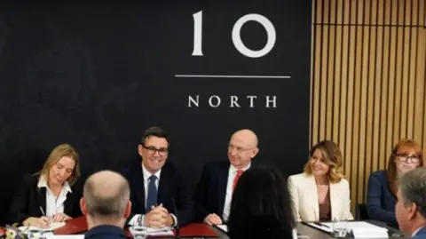 HM Treasury Cabinet members sit round a table in No 10 North