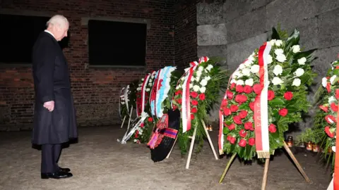 Reuters King Charles views floral tributes at 'The Death Wall' during a tour of Auschwitz