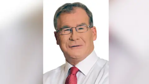 Fine Gael Colm Burke in a white shirt and red tie with black glasses