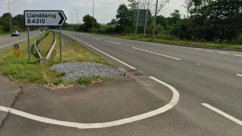 A sign on the A48 dual carriageway indicating the turn in for Llanddarog