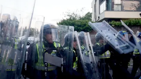 Police officers wield riot shields in a confrontation with protesters in Southampton on 2.6.26
