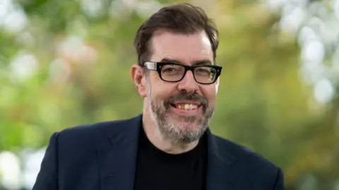 Getty Images Richard Osman outside smiling to camera 