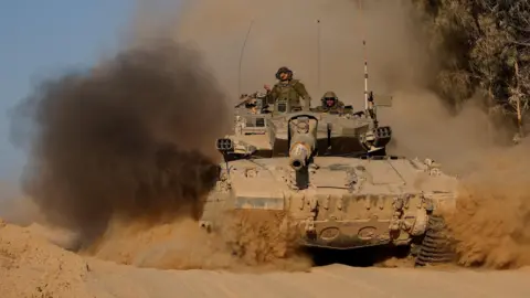 Reuters An Israeli tank manoeuvres near the Israel-Gaza border (8 July 2024) 