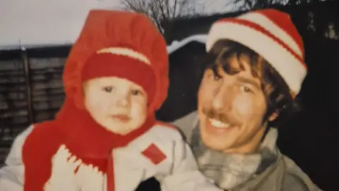 Supplied An old picture of a young Lee Coates being held by his dad Ian Coates. 