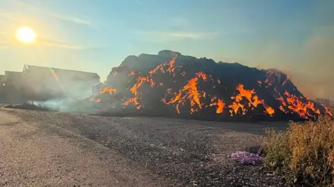 Nottinghamshire Fire and Rescue Service Haybales burning in a Nottinghamshire field the day after a fire started