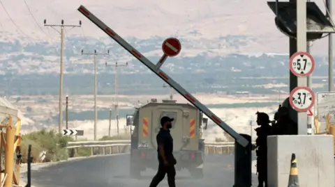 Reuters A man walks at a barrier, at the Allenby Bridge Crossing between the West Bank and Jordan