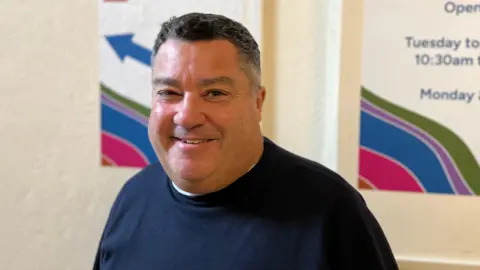 Swindon councillor Kevin Small smiles at the camera wearing a navy blue jumper.