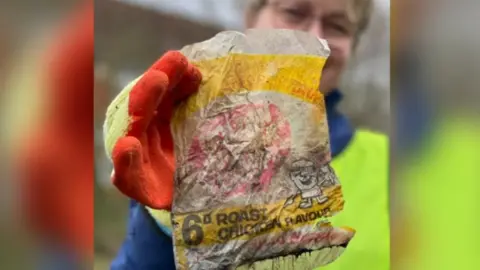 Rubbish Walks Woman holding an old crisp packet