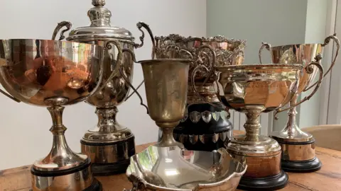 A collection of old trophies on a table.