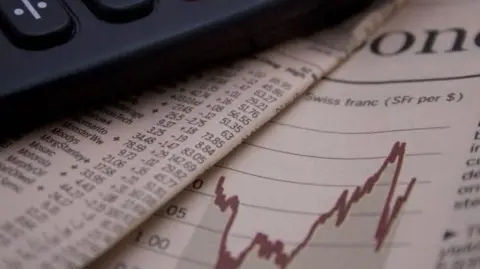 GETTY IMAGES Finances in newspaper