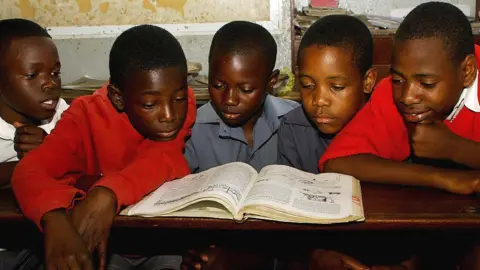 AFP Children reading from a textbook in Harare, Zimbabwe - 2009
