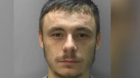 Sussex Police A mugshot of Kyle Dumble, who has been convicted of murder, attempted grievous bodily harm with intent and driving while disqualified and without insurance. He has a short beard and brown hair.