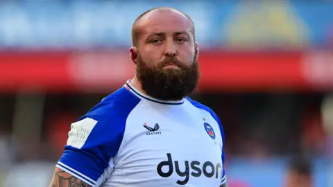 Tom Dunn standing on the pitch this season during a Premiership match