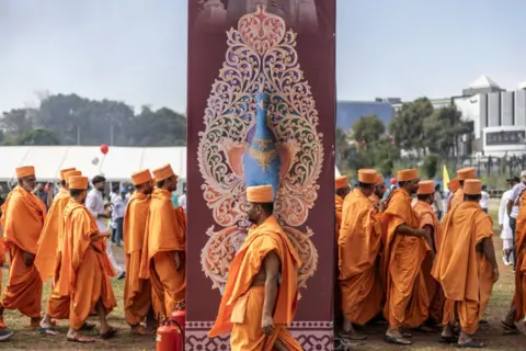 ROBERTA CIUCCIO / AFP Men gather wearing the same orange gowns and matching head covering.