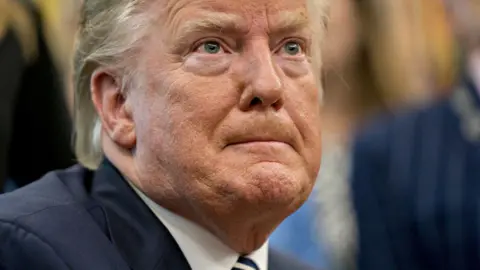 Close-up of President Donald Trump as he listens intently during an event commemorating the 50th anniversary of the Apollo 11 moon landing in the Oval Office of the White House