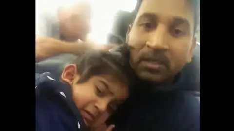 SIMONE CAMERON A video still of Nadesalingam holding Tharunicaa on the plane