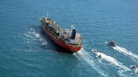 EPA/TASNIM NEWS AGENCY A handout photo made available by the Tasnim News agency shows Iranian Revolutionary Guard Corps (IRGC) jet boats seizing a South-Korean flagged tanker named Hankuk Chemi in Persian Gulf, 04 January 2021.