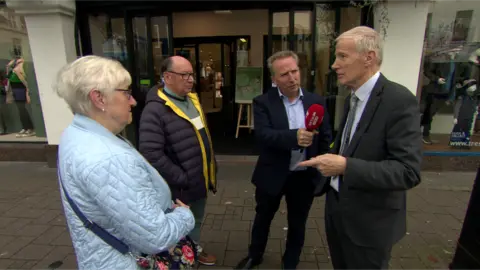 DUP MP Gregory Campbell (Right) speaks to a couple in Coleraine