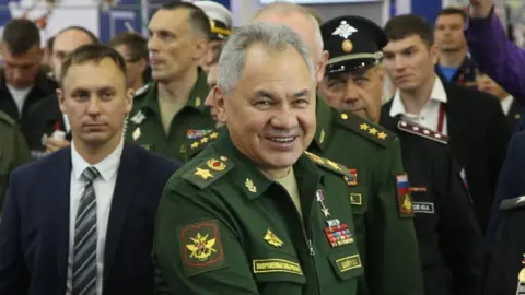 Getty Images Russian defence minister Sergei Shoigu, in military uniform, surrounded by his staff