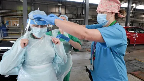 PA Media Medical staff put on their personal protective equipment.