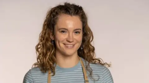 Love Productions/Channel 4/PA Tasha Stones wearing a striped top and an apron