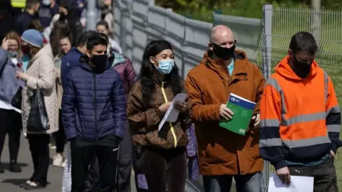PA Media People queuing for vaccines in Bolton